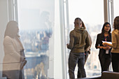 Business people talking at office window