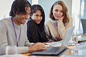 Business people using laptop in meeting