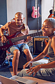 Musicians with laptop and electric guitar working