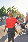 Portrait female musician carrying drum in street