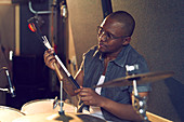 Male drummer with drum brush in recording studio