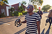 Happy male musician with tambourine on street