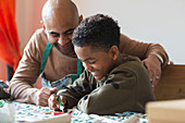 Happy father and son decorating Christmas cookies