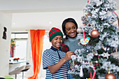Happy mother and son decorating Christmas tree