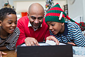 Father and sons opening Christmas gift