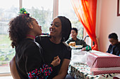 Mother and daughter wrapping Christmas gift