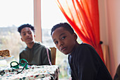 Portrait serious brothers at dining table