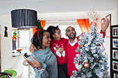 Happy family decorating Christmas tree