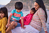 Happy mother and kids relaxing on beach