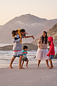 Happy family playing on ocean beach