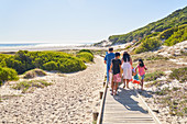 Family walking on beach boardwalk, South Africa