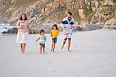 Happy family running on beach