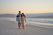 Couple walking on tranquil ocean beach