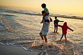 Family splashing and playing in ocean surf