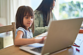 Girl homeschooling at laptop