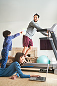 Kids in living room with father on treadmill