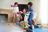 Mother and kids exercising in living room