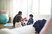 Mother and kids exercising on yoga mat