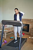Woman exercising on treadmill in living room