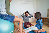 Father and kids exercising in living room