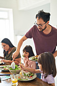 Family eating salad lunch at table