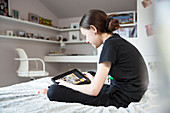 Girl e-learning with digital tablet on bed