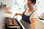 Woman cooking hamburgers on kitchen stove