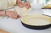 Close up woman cutting edge of pie crust