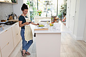 Woman with smart phone baking