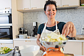 Smiling woman weighing apples for baking