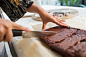 Close up woman slicing brownies with knife