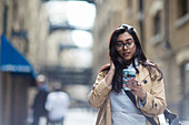 Businesswoman using smart phone on sidewalk