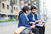 Business people working on outdoor bench