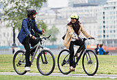 Business people riding bicycles in city park