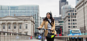 Smiling businesswoman walking bicycle