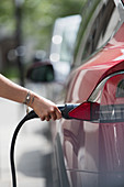 Woman recharging electric car