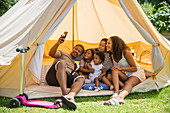 Family taking selfie inside summer tent
