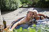 Senior couple relaxing in hot tub on patio