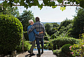 Senior couple hugging on summer garden patio