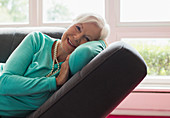 Carefree senior woman relaxing on lounge chair