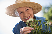 Senior woman gardening in straw hat