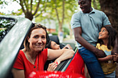 Portrait happy woman with family at convertible