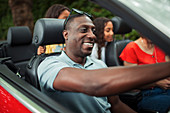 Happy man driving convertible with family
