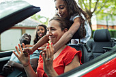 Playful family riding in convertible