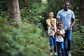 Happy family hiking on trail in woods