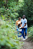 Happy family hiking on trail in woods