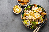 Fresh Caesar salad with lettuce salad, chicken breast, boiled eggs and croutons