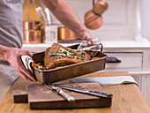 Grilled crispy roast pork being removed from the oven