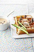 A waffle with green asparagus and morel mushroom cream