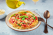 Spaghetti with tomato sauce, cheese and basil, pouring olive oil